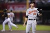 Baltimore Orioles starting pitcher Jack Flaherty (15) spits as he waits for a new baseball after giving up a home run to Arizona Diamondbacks' Lourdes Gurriel Jr., left, during the first inning of a baseball game, Sunday, Sept. 3, 2023, in Phoenix. (AP Photo/Ross D. Franklin)