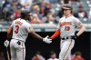 Baltimore Orioles' Heston Kjerstad (13) celebrates with Jorge Mateo (3) after scoring on a double by Jordan Westburg off Cleveland Guardians starting pitcher Triston McKenzie during the second inning of a baseball game, Sunday, Sept. 24, 2023, in Cleveland. (AP Photo/Ron Schwane)