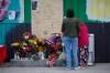 JOHN WOODS / WINNIPEG FREE PRESS FILES
                                People look at a memorial for Jung Ja Shin, the convenience store owner who died in 2021.