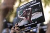 A woman holds a photo during the 'Jewish Community Vigil' for Israel in London, Monday, Oct. 9, 2023 two days after Hamas fighters launched an unprecedented, multi-front attack on Israel which killed more than 700 people. The militants blew through a fortified border fence and gunned down civilians and soldiers in Israeli communities along the Gaza frontier during a Jewish holiday. (AP Photo/Kin Cheung)