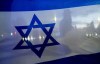 A demonstrator crossing the street is silhouetted behind a flag of Israel during a rally in support of Israel Monday, Oct. 9, 2023, in Bellevue, Wash. (AP Photo/Lindsey Wasson)
