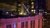 File - Workers install lighting on an 