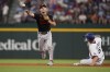 Baltimore Orioles second baseman Adam Frazier, left, forces out Texas Rangers' Corey Seager (5) at second base and completes the throw to first for the out on Mitch Garver on a double play ball hit in the fourth inning of Game 3 of a baseball AL Division Series on Tuesday, Oct. 10, 2023, in Arlington, Texas. (AP Photo/Tony Gutierrez )