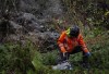 Seattle Parks and Recreation respond to a landslide Tuesday, Dec. 5, 2023, on Burke-Gilman Trail in Seattle. An atmospheric river is bringing heavy rain, flooding and warm winter temperatures to the Pacific Northwest. The National Weather Service on Tuesday issued a flood warning for parts of western Washington state. (Luke Johnson/The Seattle Times via AP)