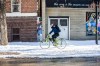 MIKAELA MACKENZIE / WINNIPEG FREE PRESS A cyclist rides through the snow in the cycling lane on Sherbrook Street on Tuesday, Oct. 31,