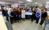 MIKE DEAL / WINNIPEG FREE PRESS
                                Kildonan MCC Thrift Shop staff and volunteers gather around CEO Lea Pawloski (left) and board chair Karin Brewer holding the cheque marking their record $1 million donation for MCC Manitoba.