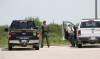 Conservation officers watch over a stand of trees on June 25, 2023, for a coyote that mauled a small boy on Knowles Avenue. (John Woods / Winnipeg Free Press files)