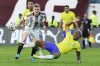 Brazil's John Kennedy, bottom, falls challenged by Argentina's Nicolas Valentini during South America's under-23 pre-Olympic tournament soccer match at Brigido Iriarte stadium in Caracas, Venezuela, Sunday, Feb. 11, 2024. (AP Photo/Ariana Cubillos)