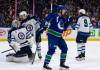 Winnipeg Jets goaltender Connor Hellebuyck (37) sits dejected as Neal Pionk (4) talks to him after Vancouver Canucks&rsquo; Pius Suter (24) scores during the third period of an NHL game, in Vancouver, Saturday, March 9, 2024. THE CANADIAN PRESS/Ethan Cairns