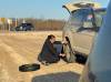 TASHA SPILLETT PHOTO 

Premier Wab Kinew changes a tire for Tasha Spillett after blowing a tire on her drive back to Winnipeg from a funeral Saturday.