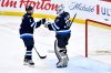 Winnipeg Jets' goaltender Connor Hellebuyck (37) celebrates the win over the Seattle Kraken with Dylan DeMelo (2) during the third period of NHL action in Winnipeg on Tuesday April 16, 2024. THE CANADIAN PRESS/Fred Greenslade