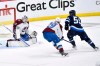 Colorado Avalanche goaltender Alexandar Georgiev (40) makes a save on Winnipeg Jets' Mark Scheifele (55) as Colorado's Nathan MacKinnon (29) defends during the first period in Game 2 of their NHL hockey Stanley Cup first-round playoff series in Winnipeg, Tuesday April 23, 2024. THE CANADIAN PRESS/Fred Greenslade