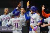 New York Mets' Jose Iglesias (11) is greeted in the dugout after scoring on a pass ball by Philadelphia Phillies catcher J.T. Realmuto during the ninth inning in a London Series baseball game at The London Stadium, in London, Sunday, June 9, 2024. (AP Photo/Kirsty Wigglesworth)