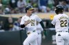 Oakland Athletics' Brent Rooker (25) looks back after he and Miguel Andujar (22) scored on a hit by Tyler Soderstrom against the Minnesota Twins during the fifth inning of a baseball game in Oakland, Calif., Friday, June 21, 2024. (AP Photo/John Hefti)