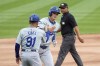Los Angeles Dodgers' Shohei Ohtani is greeted by third base coach Dino Ebel after his home run off Chicago White Sox starting pitcher Chris Flexen as umpire Erich Bacchus watches during the first inning of a baseball game Tuesday, June 25, 2024, in Chicago. (AP Photo/Charles Rex Arbogast)