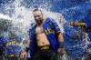 Seattle Mariners' Cal Raleigh is doused by teammates after hitting a ground ball to drive in the winning run in the 10th inning against the Minnesota Twins in a baseball game Friday, June 28, 2024, in Seattle. The Mariners won 3-2. (AP Photo/Lindsey Wasson)