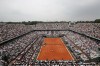 FILE - The crowd watch Austria's Dominic Thiem serving to Spain's Rafael Nadal during the men's final match of the French Open tennis tournament Roland Garros stadium in Paris, Sunday, June 10, 2018. The same courts used for the French Open each year — usually from late May to early June — will host tennis at these Olympics, so it's a surface and site familiar to the athletes, but they'll be making the unusual transition from the grass at Wimbledon to the clay at Roland Garros.(AP Photo/Christophe Ena)