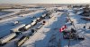 A truck convoy of anti-COVID-19 vaccine mandate demonstrators block the highway at the busy U.S. border crossing in Coutts, Alta., on Feb. 2, 2022. THE CANADIAN PRESS/Jeff McIntosh