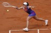 FILE - Poland's Iga Swiatek plays a shot against Italy's Jasmine Paolini during the women's final of the French Open tennis tournament at the Roland Garros stadium in Paris, France, June 8, 2024. For the first time in more than 30 years, the tennis competition at an Olympics will be held on red clay, which means players who just made the adjustment from that surface at the French Open in early June to grass at Wimbledon in early July now will need to reverse course again in short order. (AP Photo/Aurelien Morissard, File)