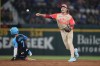 American League's Gunnar Henderson, of the Baltimore Orioles, right, throws over National League's Trea Turner, of the Philadelphia Phillies, to complete a double play on a ground ball by Bryce Harper in the third inning during the MLB All-Star baseball game, Tuesday, July 16, 2024, in Arlington, Texas. (AP Photo/Julio Cortez)