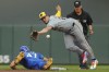 Milwaukee Brewers shortstop Willy Adames (27) reaches for the throw from the catcher as Minnesota Twins' Edouard Julien (47) safely returns to second base on a pick-off attempt in the third inning of a baseball game Saturday, July 20, 2024, in Minneapolis. (AP Photo/Bruce Kluckhohn)