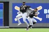 Chicago White Sox center fielder Luis Robert Jr., left, catches a fly ball off the bat of Kansas City Royals' Hunter Renfroe while dodging left fielder Tommy Pham, right, during the sixth inning of a baseball game, Sunday, July 21, 2024, in Kansas City, Mo. (AP Photo/Reed Hoffmann)