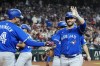 Toronto Blue Jays' Kevin Kiermaier, right, waves to the crowd as he celebrates his grand slam against the Arizona Diamondbacks with Blue Jays' George Springer (4) during the fourth inning of a baseball game, Sunday, July 14, 2024, in Phoenix. (AP Photo/Ross D. Franklin)