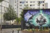Buildings and graffitis are pictures during the opening ceremony of the 2024 Summer Olympics, Friday, July 26, 2024 in the Franc-Moisin housing project in Saint-Denis, outside Paris. Residents of one Paris neighborhood say they passed on the opening ceremony after being overlooked. For many in Saint-Denis, the Olympics feel like a distant spectacle. (AP Photo/Tom Nouvian)