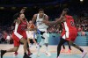 Giannis Antetokounmpo, of Greece, drives between Dillon Brooks, left, and Shai Gilgeous-Alexander, of Canada, in a men's basketball game at the 2024 Summer Olympics, Saturday, July 27, 2024 in Villeneuve-d'Ascq, France. (AP Photo/Mark J. Terrill)
