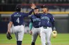 Seattle Mariners' Josh Rojas, left, Jorge Polanco (7) and Dylan Moore celebrate the team's 6-3 win over the Chicago White Sox after a baseball game Saturday, July 27, 2024, in Chicago. (AP Photo/Charles Rex Arbogast)