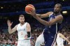 Kevin Durant, right, of the United States, passes the ball as he heads out of bounds while under pressure from Marko Guduric, of Serbia, in a men's basketball game at the 2024 Summer Olympics, Sunday, July 28, 2024, in Villeneuve-d'Ascq, France. (AP Photo/Michael Conroy)