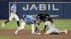 Tampa Bay Rays shortstop Taylor Walls, left, and umpire Edwin Moscoso, center, watch as Cincinnati Reds' Elly De La Cruz (44) bats the tag from Brandon Lowe for a stolen base during the sixth inning of a baseball game, Sunday, July 28, 2024, in St. Petersburg, Fla. (AP Photo/Steve Nesius)