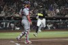 Arizona Diamondbacks' Lourdes Gurriel Jr., right, runs to score against the Washington Nationals on a double hit by Kevin Newman in the fourth inning during a baseball game, Monday, July 29, 2024, in Phoenix. (AP Photo/Rick Scuteri)