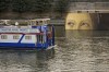 A ship sails past reproductions of artworks decorating the banks of the River Seineat the 2024 Summer Olympics, Tuesday, July 30, 2024, in Paris, France. The men's Olympic triathlon has been postponed over concerns about water quality in Paris' Seine River, where the swimming portion of the race was supposed to take place. (AP Photo/ Dar Yasin)