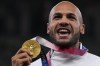 FILE - Lamont Marcell Jacobs, of Italy poses with his gold medal following the men's 100-meters final at the 2020 Summer Olympics, Monday, Aug. 2, 2021, in Tokyo. (AP Photo/Francisco Seco, File)
