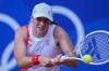 Iga Swiatek of Poland returns a shot to Anna Karolina Schmiedlova of Slovakia during their women's bronze medal match, at the 2024 Summer Olympics, Friday, Aug. 2, 2024, at the Roland Garros stadium in Paris, France. (AP Photo/Andy Wong)