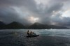 Members of the water safety team look on from a jet ski as the sun rises on a training day ahead of the 2024 Summer Olympics surfing competition, Tuesday, July 23, 2024, in Teahupo'o, Tahiti. (AP Photo/Gregory Bull)