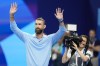 Former Olympic champion Michael Phelps, from the United States, waves to fans ahead of the evening swimming session at the 2024 Summer Olympics, Sunday, July 28, 2024, in Nanterre, France. (AP Photo/Martin Meissner)