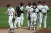 Pittsburgh Pirates relief pitcher Jake Woodford (46) walks to the dugout after handing the ball to manager Derek Shelton, second from left, during the fifth inning of a baseball game against the San Diego Padres in Pittsburgh, Tuesday, Aug. 6, 2024. (AP Photo/Gene J. Puskar)