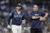 Seattle Mariners' Justin Turner walks with a trainer after he is hit by a pitch from Detroit Tigers pitcher Will Vest during the seventh inning in a baseball game, Tuesday, Aug. 6, 2024, in Seattle. (AP Photo/John Froschauer)
