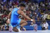 Ukraine's Zhan Beleniuk leaves his shoes in the ring as he retires after beating Poland's Arkadiusz Marcin Kulynycz during their men's Greco-Roman 87kg bronze medal wrestling match, at Champ-de-Mars Arena, during the 2024 Summer Olympics, Thursday, Aug. 8, 2024, in Paris, France. (AP Photo/Eugene Hoshiko)