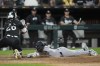 New York Yankees' Jazz Chisholm Jr., right, dives by Chicago White Sox catcher Korey Lee, left, to score on a single by Anthony Volpe during the fifth inning of a baseball game Monday, Aug. 12, 2024, in Chicago. (AP Photo/Erin Hooley)