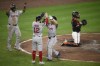 Boston Red Sox's Masataka Yoshida, second from right, celebrates his three-run home run with Connor Wong (12) and Rafael Devers, top left, during the fourth inning of a baseball game against the Baltimore Orioles, Friday, Aug. 16, 2024, in Baltimore. Orioles catcher James McCann looks on at right. (AP Photo/Nick Wass)