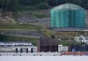 The West Coast Express passenger train passes in front of Kinder Morgan's Trans-Mountain marine terminal, in Burnaby, B.C., on May 29, 2018. The operator of British Columbia's commuter train that shuttles thousands of people across the Lower Mainland says it won't be able to run if Canada's rail services come to a halt this week. THE CANADIAN PRESS Jonathan Hayward