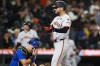 San Francisco Giants' Michael Conforto, right, reacts as he crosses home after hitting a two-run home run as Seattle Mariners catcher Cal Raleigh wipes his eyes during the fourth inning of a baseball game Friday, Aug. 23, 2024, in Seattle. (AP Photo/Lindsey Wasson)