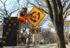 City of Winnipeg worker with Traffic Services puts up new signs on Grosvenor Ave informing traffic of roundabouts Tuesday afternoon. (Ruth Bonneville / Free Press files)