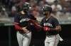 Minnesota Twins' Trevor Larnach, left, congratulates Willi Castro, on his home run in the eighth inning of a baseball game against the Cleveland Guardians, Tuesday, Sept. 17, 2024, in Cleveland. (AP Photo/Sue Ogrocki)