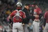 Arizona Diamondbacks pitching coach Brent Strom, center, confers with relief pitcher Blake Walston as catcher Jose Herrera looks on after Walston gave up an RBI single to Colorado Rockies' Brendan Rodgers in the eighth inning of a baseball game Tuesday, Sept. 17, 2024, in Denver. (AP Photo/David Zalubowski)