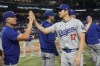 Los Angeles Dodgers' Shohei Ohtani (17) is congratulated by a coach at the end of a baseball game against the Miami Marlins, Thursday, Sept. 19, 2024, in Miami. (AP Photo/Marta Lavandier)