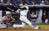 New York Yankees' Juan Soto, right, follows through on single during the sixth inning of a baseball game against the Baltimore Orioles, Thursday, Sept. 26, 2024, in New York. (AP Photo/Noah K. Murray)
